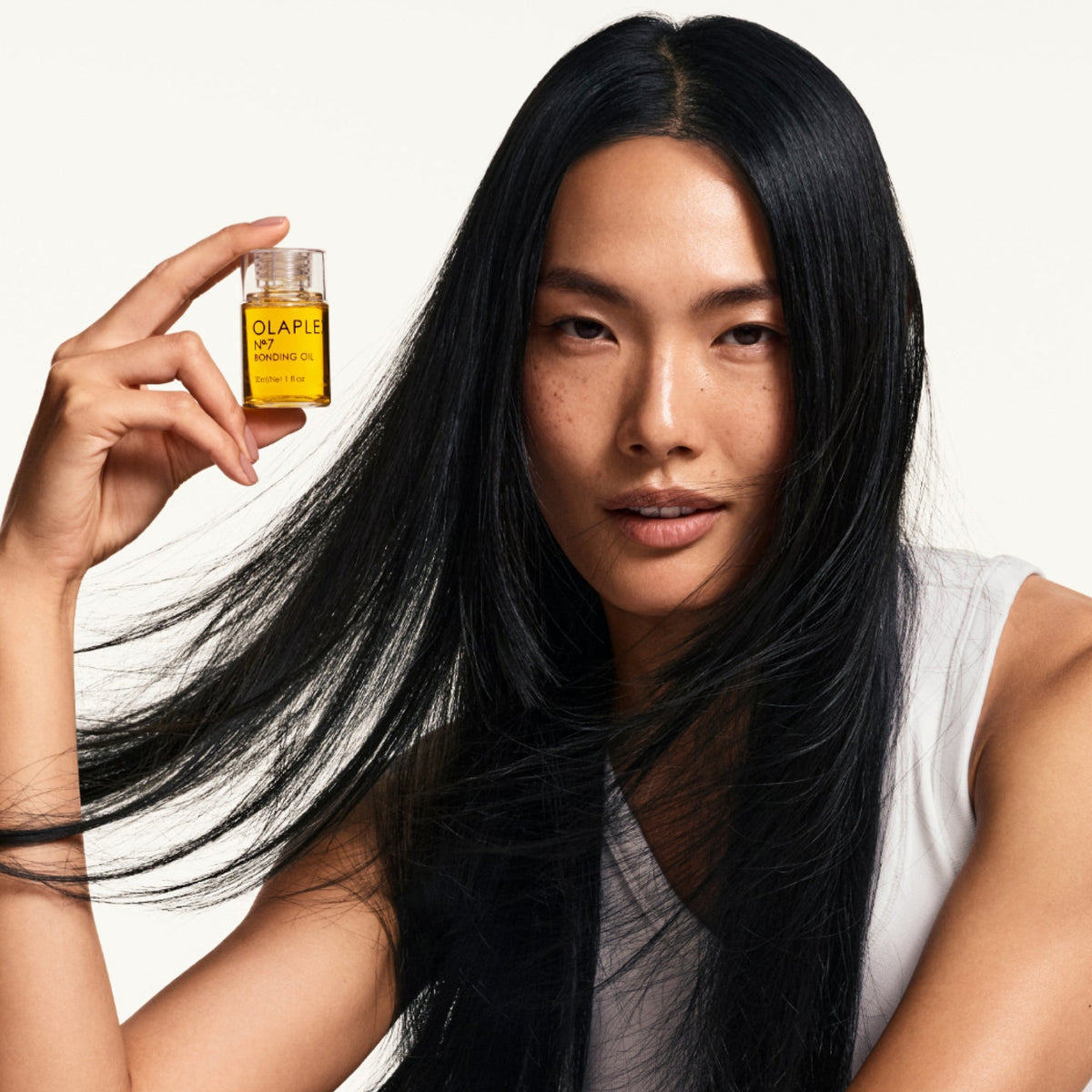Woman holding OLAPLEX Nº.7