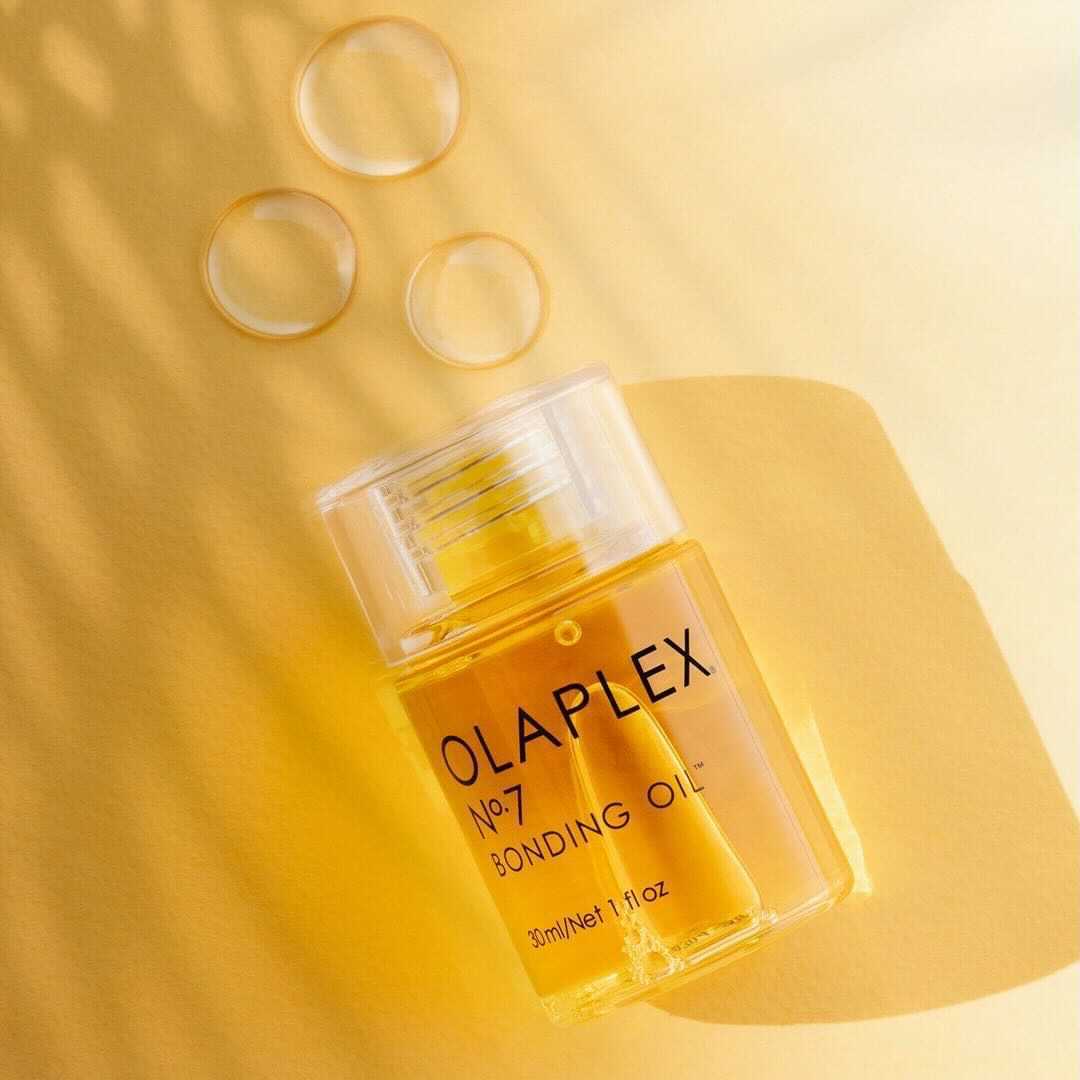 OLAPLEX® No.7 Bonding Oil on a yellow surface