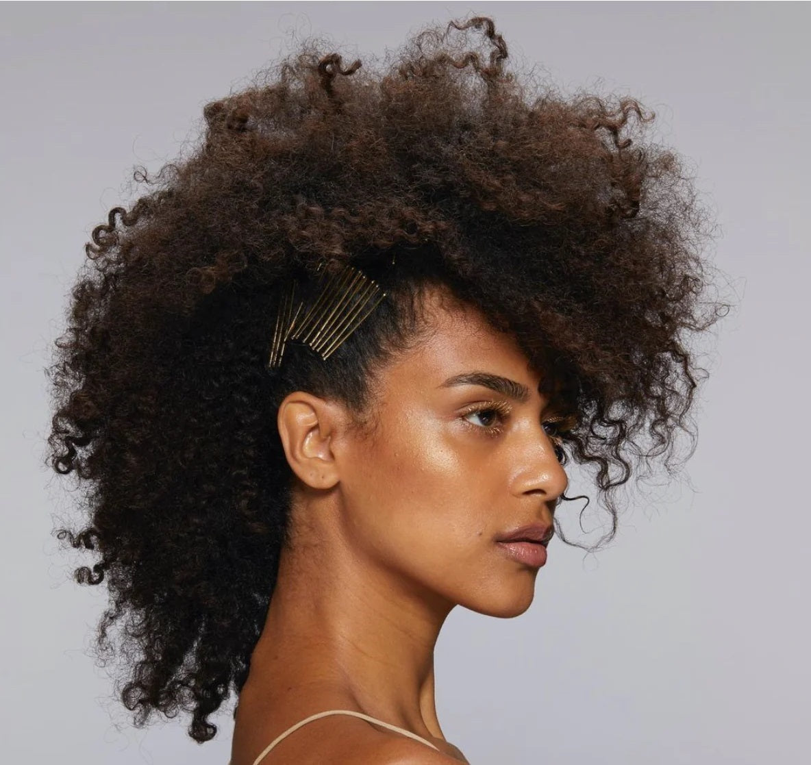 Woman with hair pins in her coily hair