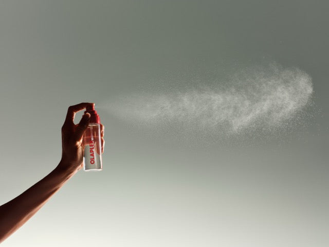 OLAPLEX Signature Hair & Body Mist is sprayed into the air