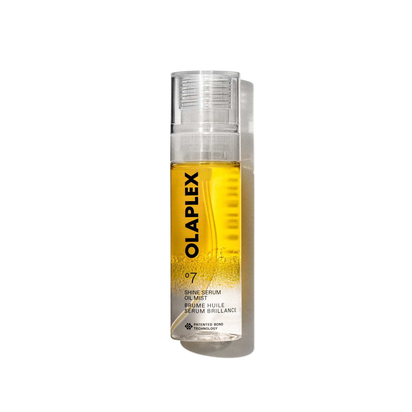 Photo du produit Olaplex No. 7 Shine Serum Oil Mist dans un flacon pulvérisateur transparent de 80 ml. La bouteille présente un liquide jaune vif visible à l'intérieur, un capuchon transparent et une étiquette blanche propre au bas avec un texte noir affichant le nom du produit, les détails et la signature "No. 7 " logo. La bouteille est isolée sur un fond quadrillé transparent.
