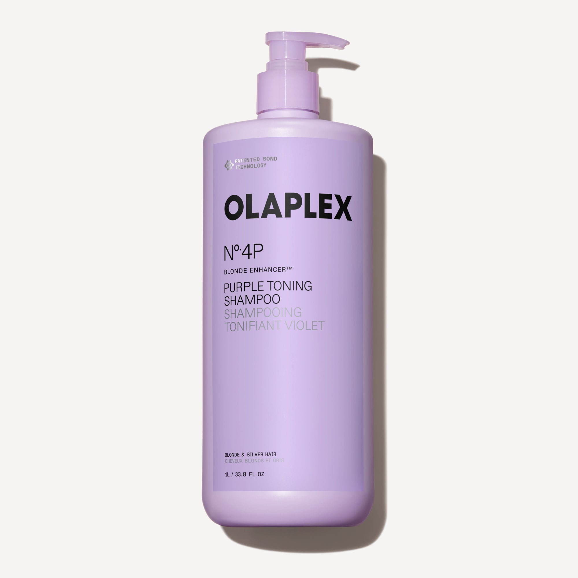 A one-liter bottle of Olaplex No. 4P Blonde Enhancer Purple Toning Shampoo with a pump dispenser, centered against a clean white background.