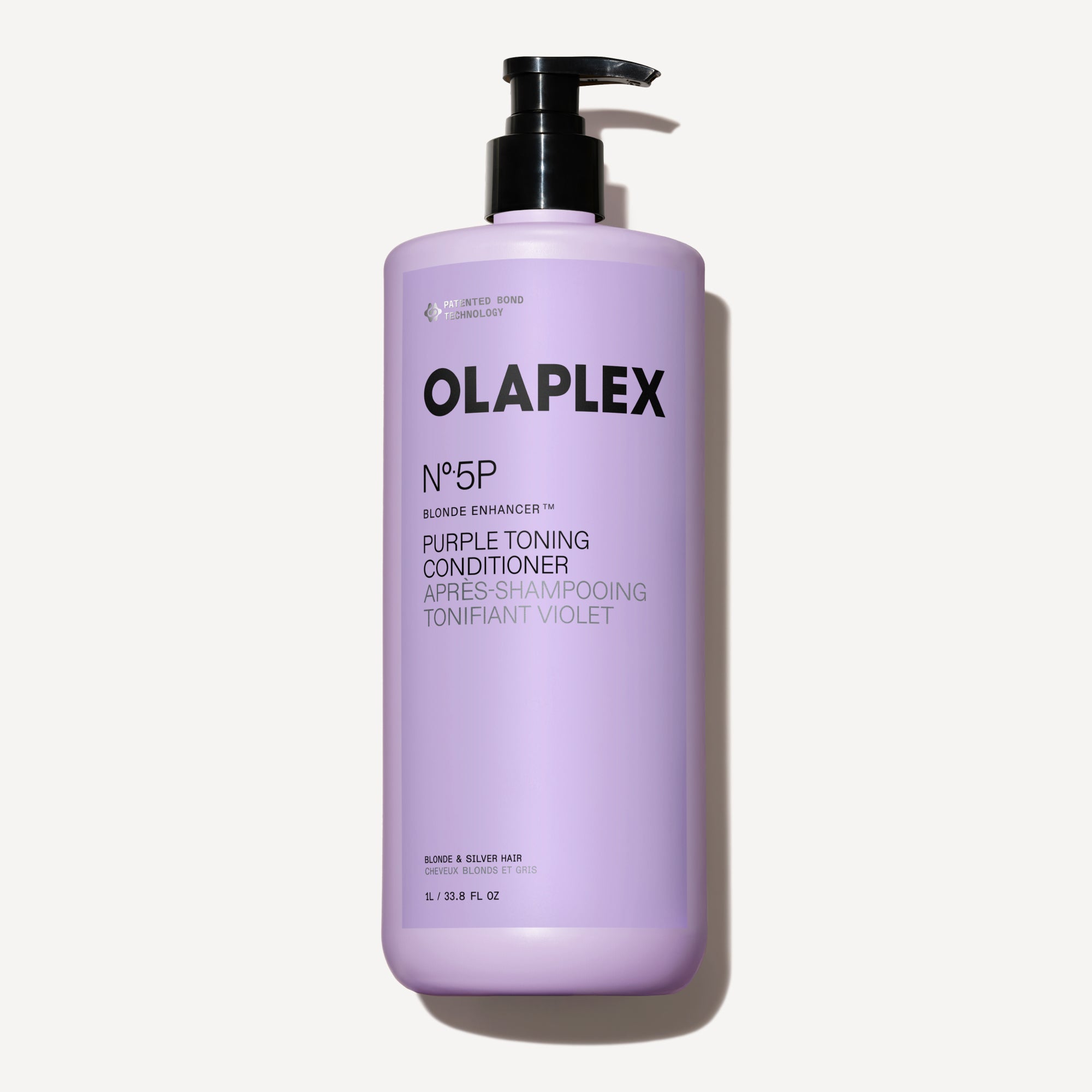 A one-liter bottle of Olaplex No. 5P Purple Toning Conditioner with a black pump dispenser, centered against a dark checkered background.