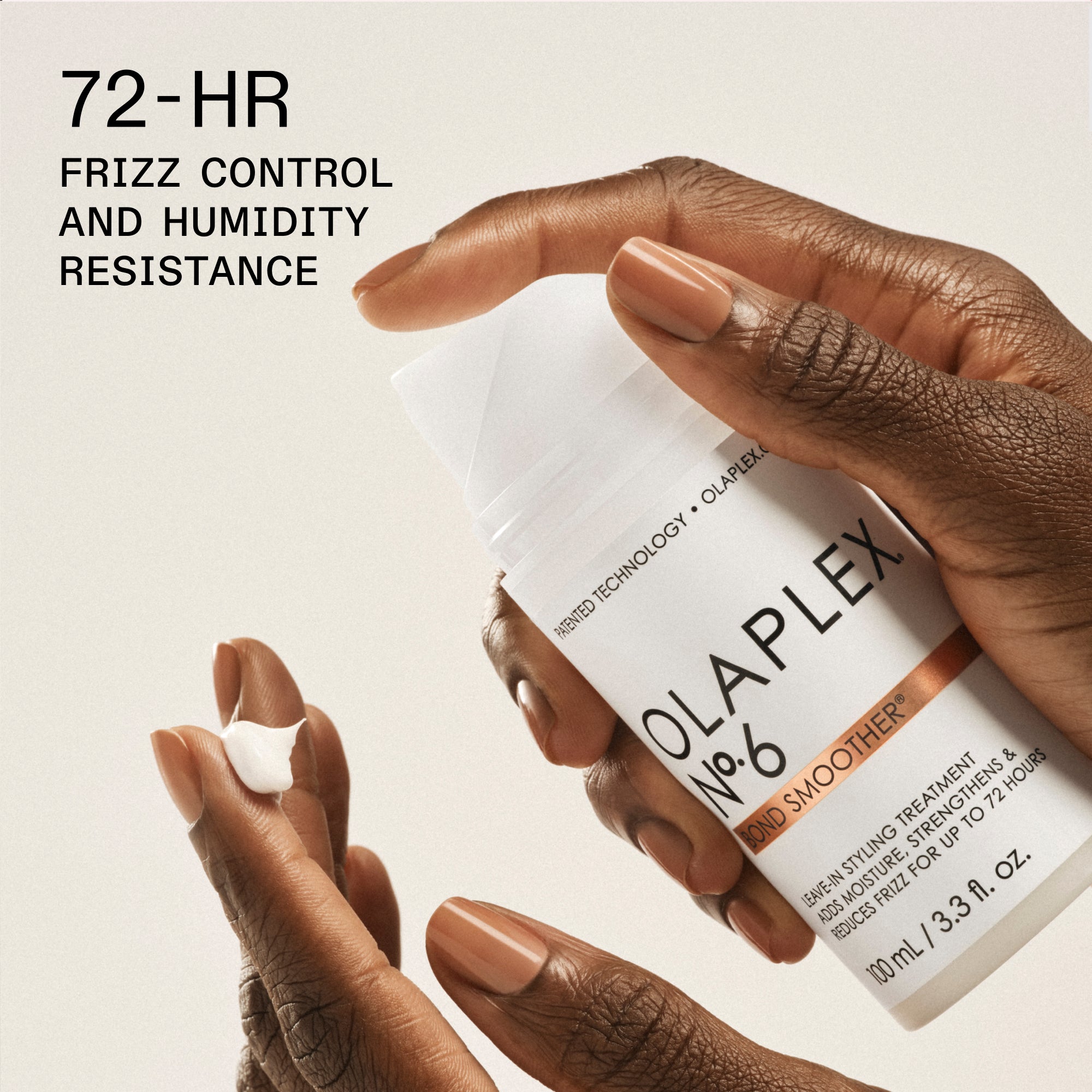 Un plan rapproché de la main d'une personne avec des ongles peints en brun tenant un flacon blanc d'« OLAPLEX N°.6 BOND SMOOTHER® traitement de coiffage sans rinçage (100 ml / 3,3 oz liq.) ». Dans le coin inférieur gauche, une petite boule de crème blanche repose sur le bout des doigts de la personne. Le texte noir en gras dans le coin supérieur gauche indique « 72 HEURES DE CONTRÔLE DES FRISOTTIS ET DE RÉSISTANCE À L’HUMIDITÉ ».